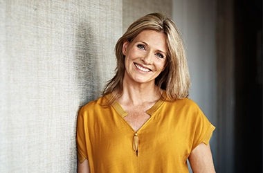 Woman Smiling Leaning On Wall